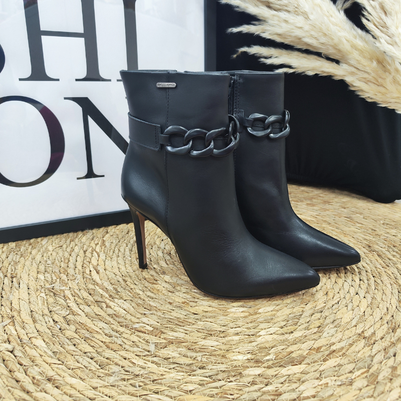 Esta bota é uma escolha elegante e versátil para mulheres que desejam adicionar um toque de sofisticação ao seu visual. Pode ser usada numa variedade de ocasiões, desde eventos formais, como festas e jantares, até situações mais casuais, combinando com roupas do dia a dia.  Com fecho de correr na lateral, para facilitar o calçar e detalhe decorativo de corrente em acrílico, que adiciona um toque extra de estilo e personalidade á bota.