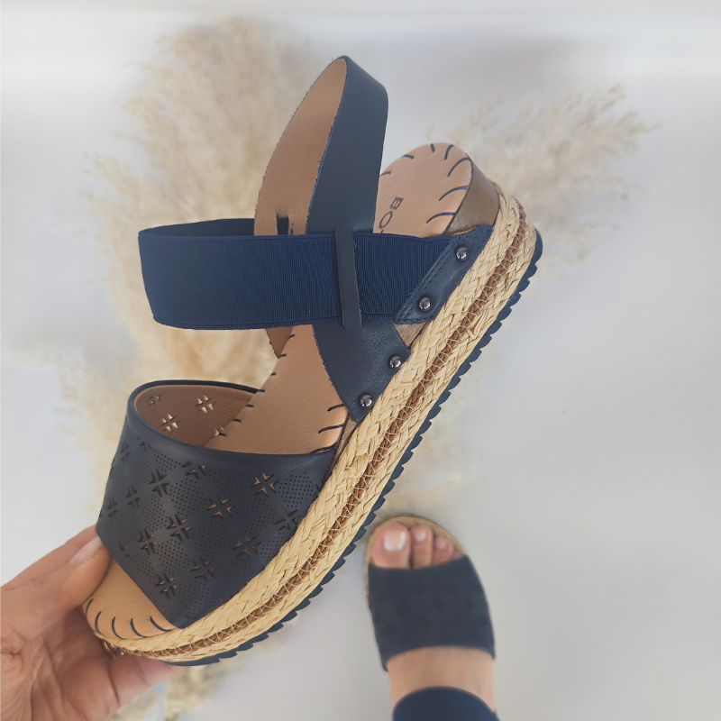 Elegante e confortável, esta sandália combina estilo e praticidade para os dias quentes. Com elástico no peito do pé, mais cómodo e fácil de calçar. A plataforma de borracha com detalhe em ráfia trançada, oferece estilo e segurança com a sola antiderrapante.