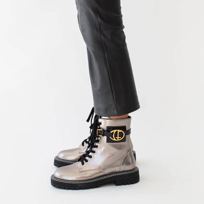 Estas botas estilo militar, são uma escolha elegante para quem procura uma bota que une moda e funcionalidade. A combinação do estilo militar com a cor bronze metalizado torna estas botas exclusivas e estilosas. São ideais para criar looks ousados e urbanos, enquanto proporcionam conforto e durabilidade. O toque distintivo destas botas é o acessório com o branding CF. Este detalhe acrescenta personalidade e exclusividade ao design sendo uma característica de destaque.