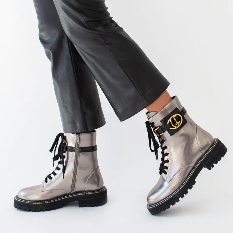 Estas botas estilo militar, são uma escolha elegante para quem procura uma bota que une moda e funcionalidade. A combinação do estilo militar com a cor bronze metalizado torna estas botas exclusivas e estilosas. São ideais para criar looks ousados e urbanos, enquanto proporcionam conforto e durabilidade. O toque distintivo destas botas é o acessório com o branding CF. Este detalhe acrescenta personalidade e exclusividade ao design sendo uma característica de destaque.