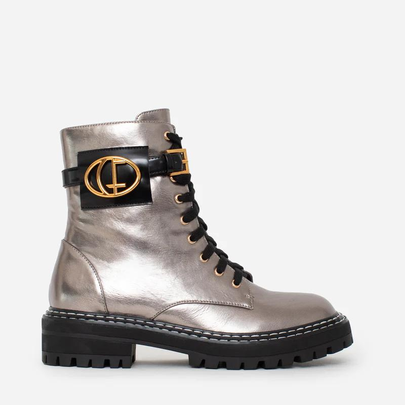 Estas botas estilo militar, são uma escolha elegante para quem procura uma bota que une moda e funcionalidade. A combinação do estilo militar com a cor bronze metalizado torna estas botas exclusivas e estilosas. São ideais para criar looks ousados e urbanos, enquanto proporcionam conforto e durabilidade. O toque distintivo destas botas é o acessório com o branding CF. Este detalhe acrescenta personalidade e exclusividade ao design sendo uma característica de destaque.