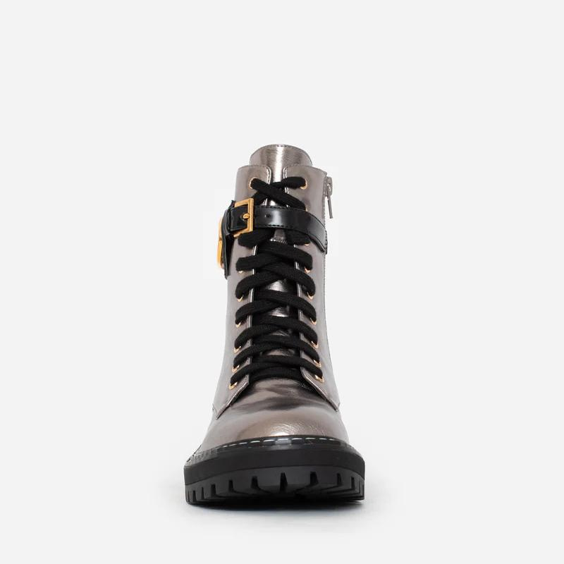 Estas botas estilo militar, são uma escolha elegante para quem procura uma bota que une moda e funcionalidade. A combinação do estilo militar com a cor bronze metalizado torna estas botas exclusivas e estilosas. São ideais para criar looks ousados e urbanos, enquanto proporcionam conforto e durabilidade. O toque distintivo destas botas é o acessório com o branding CF. Este detalhe acrescenta personalidade e exclusividade ao design sendo uma característica de destaque.