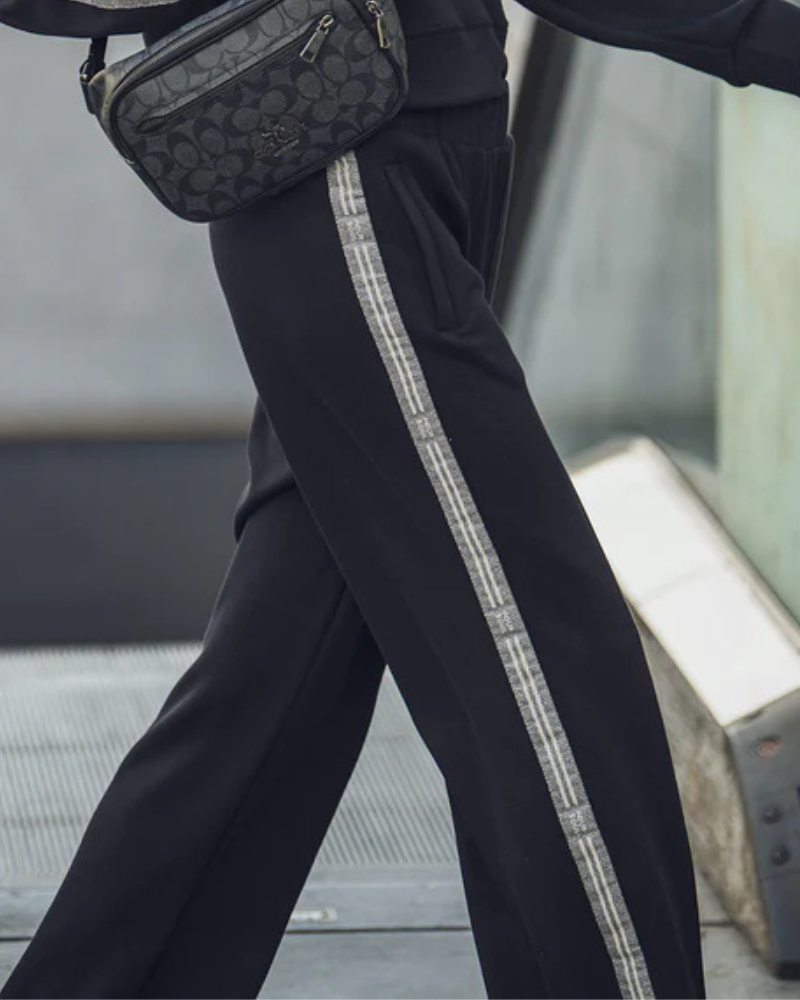 Estas calças de estilo training combinam conforto e modernidade numa peça versátil para o dia a dia.
Confeccionadas em tecido macio e leve, oferecem liberdade de movimento e um ajuste descontraído. O destaque fica por conta das tiras laterais em padrão contrastante, que acrescentam um toque desportivo e contemporâneo ao seu visual.