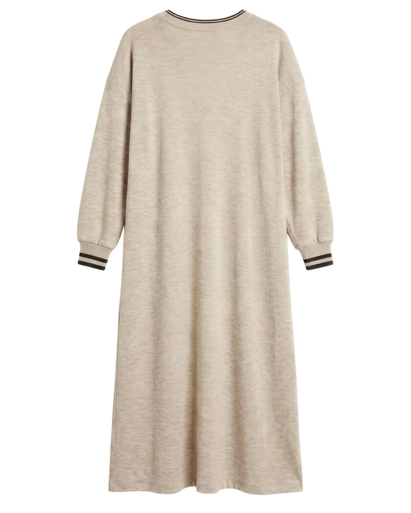 Elegância e conforto unem-se neste vestido.
Em malha de toque macio e decote em V decorado com riscas contrastantes que acrescentam um toque desportivo e elegante. Apresenta mangas compridas com punhos também contrastantes, corte ligeiramente evasé e comprimento midi, criando uma silhueta feminina e descontraída.