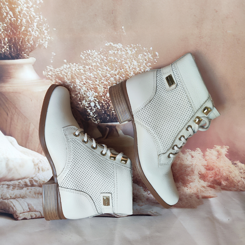Estas botas de cano curto combinam praticidade com um design elegante e moderno.
Fabricadas em couro texturizado, apresentam detalhes em metal dourado nas ilhoses e um acabamento impecável que exala sofisticação. O modelo com amarração em atacadores oferece um ajuste personalizado, enquanto o salto baixo e grosso garante conforto e estabilidade para o uso diário.