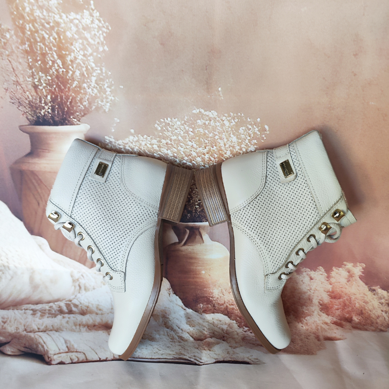Estas botas de cano curto combinam praticidade com um design elegante e moderno.
Fabricadas em couro texturizado, apresentam detalhes em metal dourado nas ilhoses e um acabamento impecável que exala sofisticação. O modelo com amarração em atacadores oferece um ajuste personalizado, enquanto o salto baixo e grosso garante conforto e estabilidade para o uso diário.