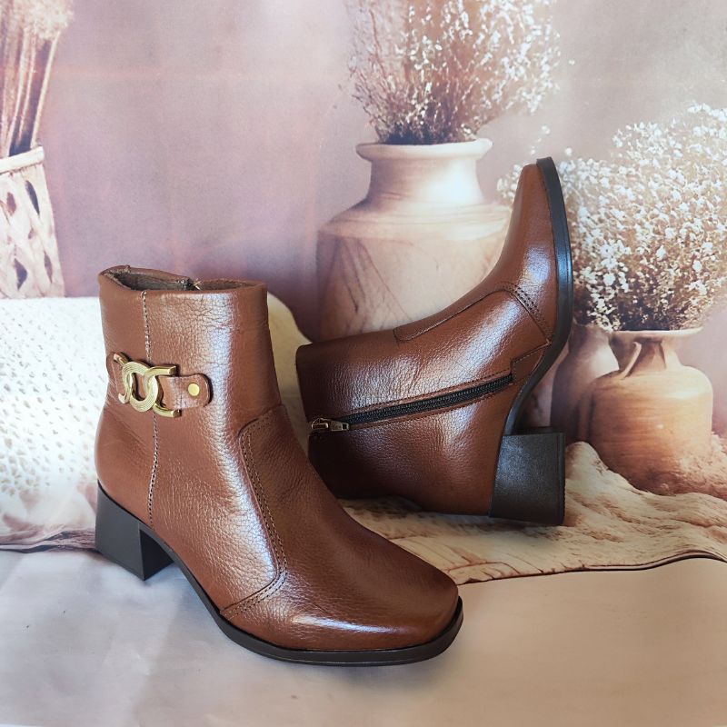 Estas botas são o exemplo perfeito de elegância intemporal com um toque de modernidade. O detalhe em metal no lado externo adiciona um charme sofisticado e faz destas botas uma peça-chave para completar looks estilosos.
O salto médio e robusto oferece conforto e estabilidade, tornando-as ideais tanto para o dia a dia quanto para ocasiões mais formais. O fechamento de correr lateral facilita o calçar e ajusta-se perfeitamente ao tornozelo.