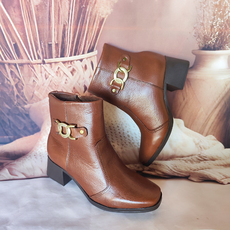 Estas botas são o exemplo perfeito de elegância intemporal com um toque de modernidade. O detalhe em metal no lado externo adiciona um charme sofisticado e faz destas botas uma peça-chave para completar looks estilosos.
O salto médio e robusto oferece conforto e estabilidade, tornando-as ideais tanto para o dia a dia quanto para ocasiões mais formais. O fechamento de correr lateral facilita o calçar e ajusta-se perfeitamente ao tornozelo.