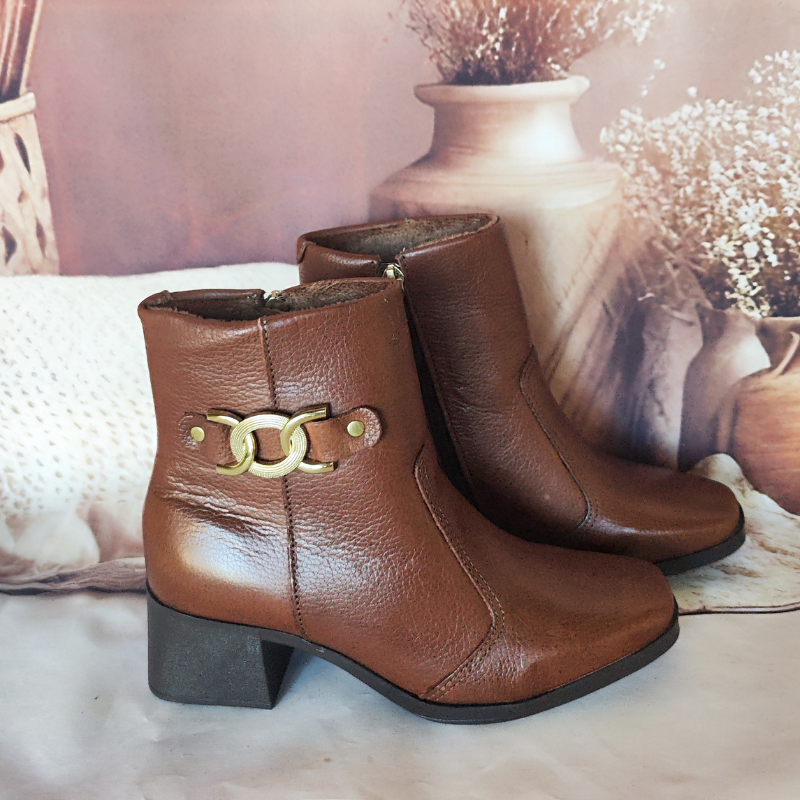 Estas botas são o exemplo perfeito de elegância intemporal com um toque de modernidade. O detalhe em metal no lado externo adiciona um charme sofisticado e faz destas botas uma peça-chave para completar looks estilosos.
O salto médio e robusto oferece conforto e estabilidade, tornando-as ideais tanto para o dia a dia quanto para ocasiões mais formais. O fechamento de correr lateral facilita o calçar e ajusta-se perfeitamente ao tornozelo.