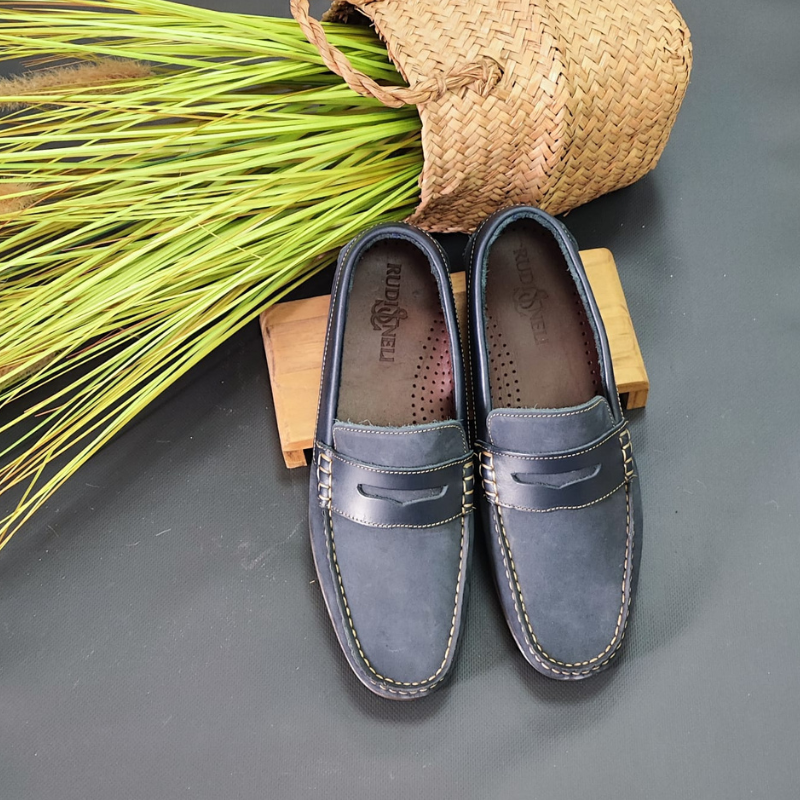 O sapato mocassim é um calçado clássico e versátil, perfeito para diversas ocasiões. Sem atacadores, desliza facilmente nos pés. Possui um estilo elegante e casual, com uma silhueta de bico arredondado e uma costura em torno da parte superior do calçado. O detalhe do travessão em couro confere um visual sofisticado. Uma das características marcantes do mocassim é o seu conforto, este modelo é projetado para se ajustar aos pés e oferecer uma sensação de leveza ao caminhar. Made in Portugal