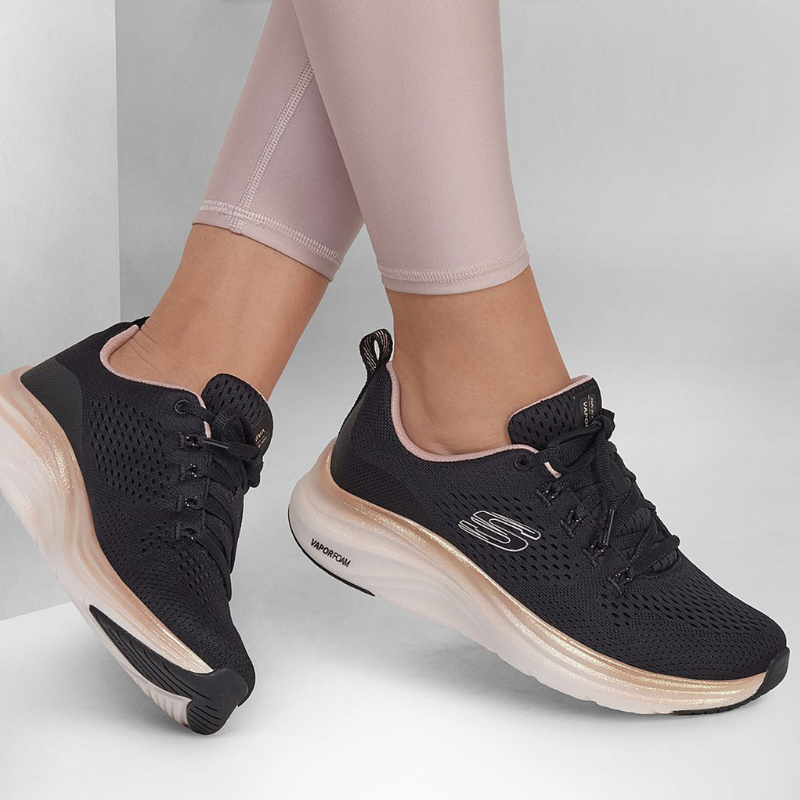 Estas sapatilhas da Skechers, modelo "Vapor Foam - Fresh Trend", combinam design moderno e tecnologia de conforto.
Com um acabamento preto elegante, apresentam detalhes em rosa claro no interior e dourado ao redor da sola, adicionando um toque de delicadeza ao visual esportivo. O tecido respirável proporciona ventilação e ajuste perfeito ao pé, enquanto a entressola em "Vapor Foam" oferece uma absorção de impacto superior, garantindo conforto durante todo o dia. 