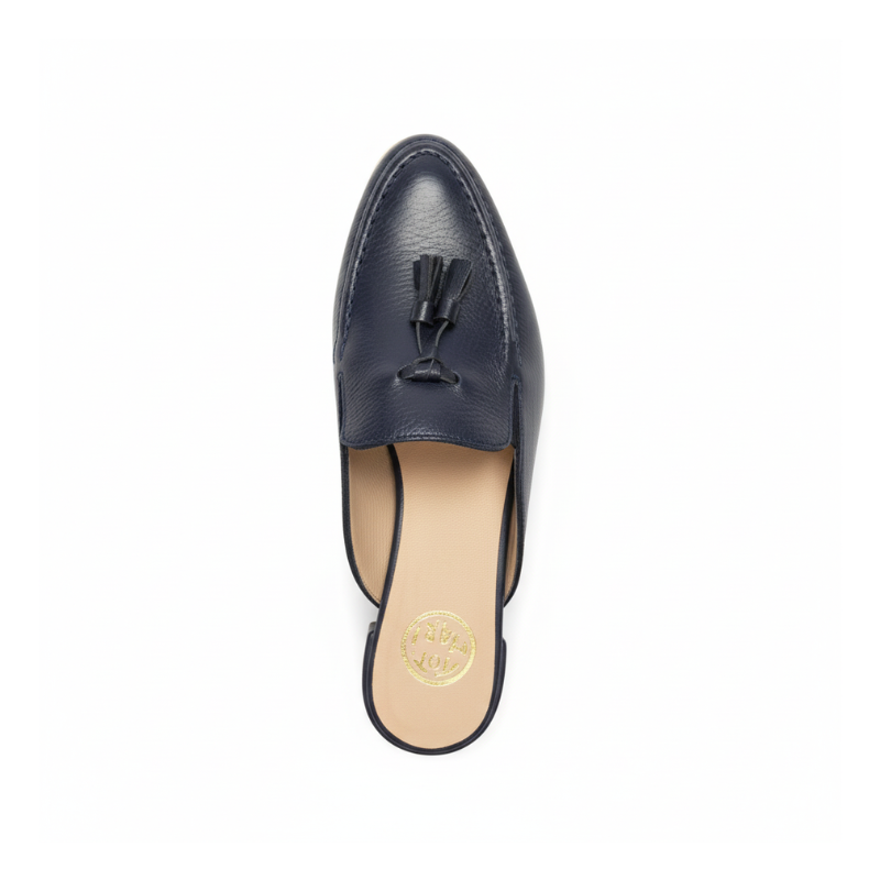 Reinvente o seu estilo com esta mule loafer em couro azul-marinho, a peça perfeita para quem procura praticidade sem abdicar da elegância.
Os berloques em couro são o elemento distintivo deste modelo, conferindo personalidade e um ar contemporâneo que se destaca. O tom azul-marinho profundo é uma alternativa sofisticada ao preto tradicional, trazendo cor ao seu guarda-roupa mantendo a versatilidade que procura.
