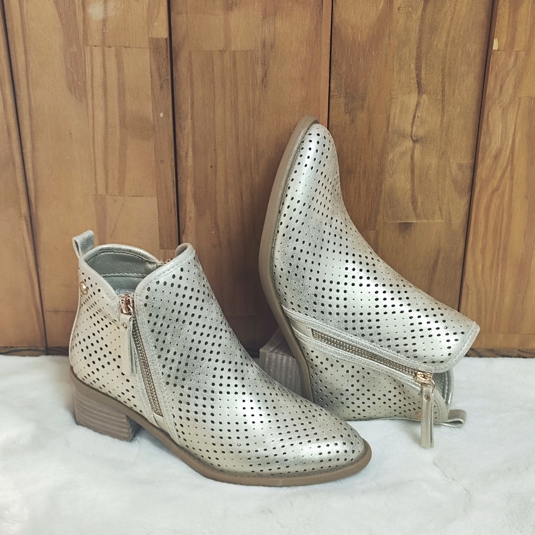Estilo e conforto em perfeita harmonia!
Este botim dourado apresenta um design moderno com acabamento vazado, proporcionando respirabilidade e um toque elegante aos seus looks. O salto em bloco oferece estabilidade e conforto para o uso diário, enquanto o fecho lateral dourado garante praticidade ao calçar.