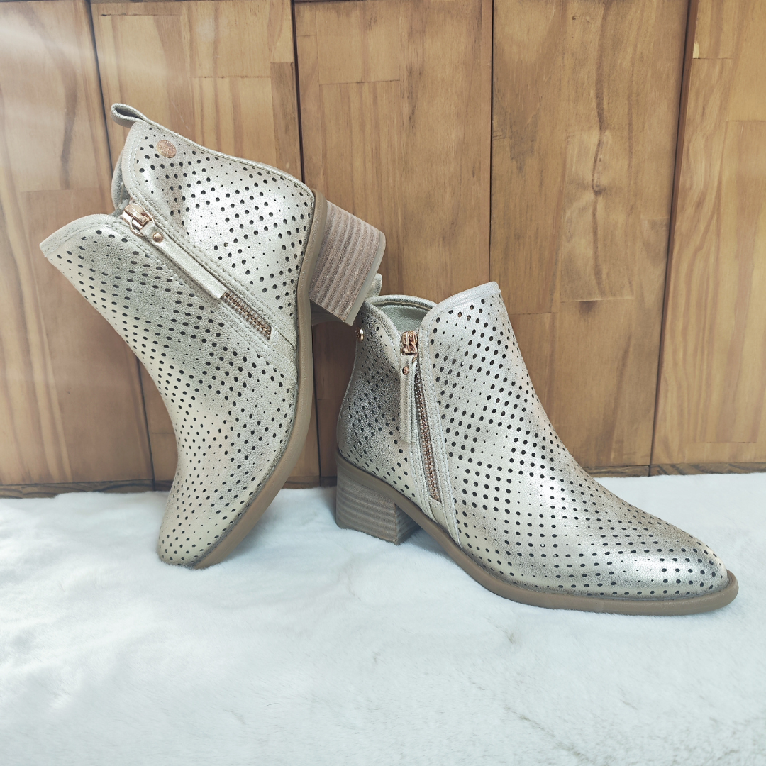 Estilo e conforto em perfeita harmonia!
Este botim dourado apresenta um design moderno com acabamento vazado, proporcionando respirabilidade e um toque elegante aos seus looks. O salto em bloco oferece estabilidade e conforto para o uso diário, enquanto o fecho lateral dourado garante praticidade ao calçar.