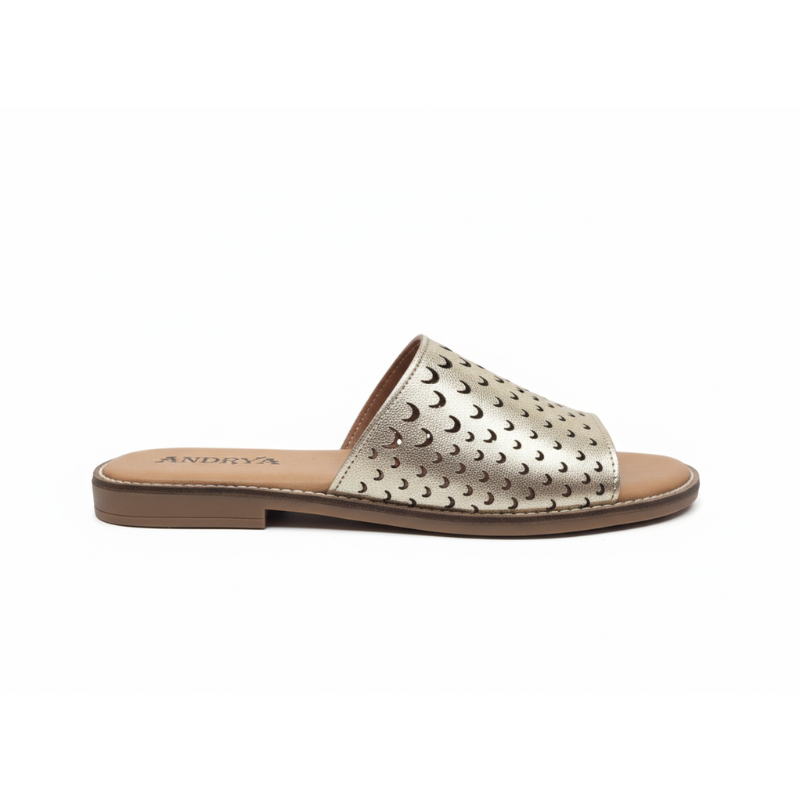 Feito para quem não abdica do estilo mesmo nos dias mais descontraídos, este chinelo raso em couro metalizado dourado é uma peça que combina conforto e sofisticação com naturalidade.

A tira larga em pele com acabamento metálico dourado apresenta um padrão de recortes em forma de lua crescente, um detalhe que confere leveza visual e um toque editorial ao design.