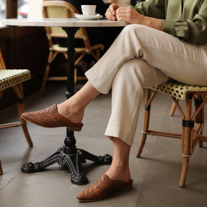 Com um design que equilibra sofisticação e conforto, esta mule plana em couro camel é uma peça de carácter inconfundível.&nbsp;

O cabedal em pele com recortes e padrão de perfurações circulares confere leveza e movimento ao modelo, enquanto a forma pontiaguda alonga a silhueta com elegância natural.