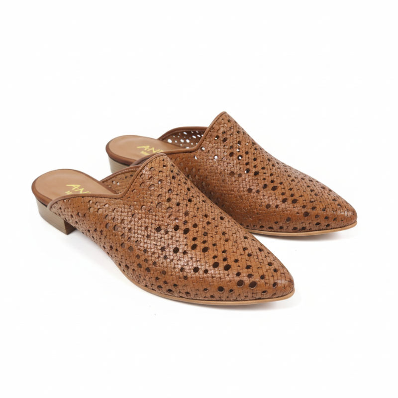 Com um design que equilibra sofisticação e conforto, esta mule plana em couro camel é uma peça de carácter inconfundível.&nbsp;

O cabedal em pele com recortes e padrão de perfurações circulares confere leveza e movimento ao modelo, enquanto a forma pontiaguda alonga a silhueta com elegância natural.