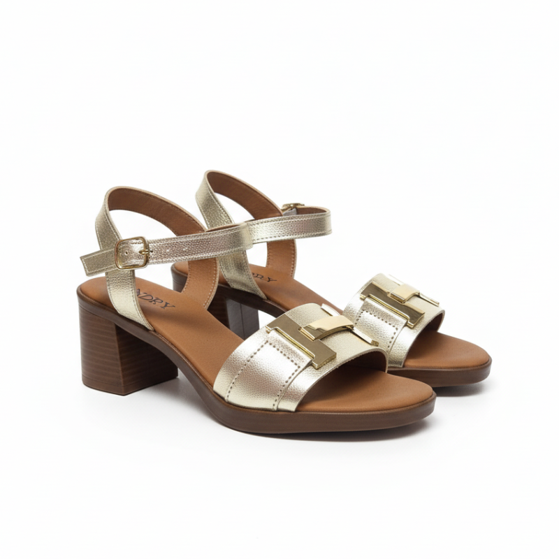 Com um design que conjuga elegância e modernidade, esta sandália de salto bloco em couro metalizado dourado eleva qualquer look com facilidade.

A tira frontal larga, decorada com uma aplicação dourada de destaque, confere ao modelo um carácter sofisticado e contemporâneo, enquanto a tira de tornozelo com fivela assegura um ajuste seguro e confortável ao longo do dia. O salto bloco, de altura média, oferece estabilidade sem abdicar da elegância — ideal para quem procura conforto sem comprometer o estilo.