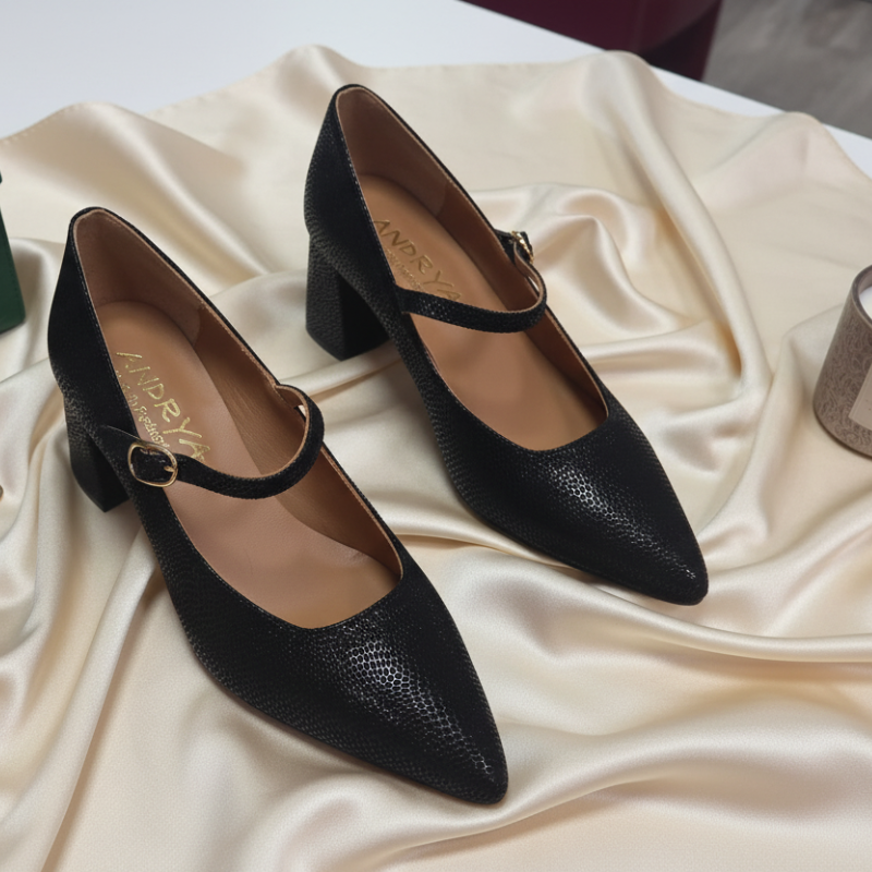 Este sapato estilo Mary Jane em couro texturizado preto é uma peça essencial que combina elegância clássica com detalhes contemporâneos.

Fabricado em couro de alta qualidade com textura granulada distintiva, este modelo oferece um acabamento luxuoso. O destaque deste sapato reside na sua fivela dourada elegante que atravessa o peito do pé, um detalhe refinado que eleva o design clássico a um novo patamar de sofisticação.