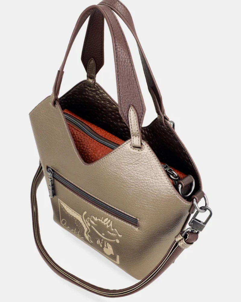 Esta carteira redefine o conceito de versatilidade com uma proposta única: duas carteiras numa só.

A bolsa principal impressiona pelo seu padrão artístico em tons de laranja, verde, bege e terracota, com uma textura trabalhada que evoca o espírito aventureiro e cosmopolita da coleção Odyssey. Os detalhes em metal gunmetal, a corrente com pendente em forma de nuvem e as alças em couro sintético castanho-escuro completam um visual rico e distinto.