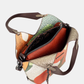 Esta carteira redefine o conceito de versatilidade com uma proposta única: duas carteiras numa só.

A bolsa principal impressiona pelo seu padrão artístico em tons de laranja, verde, bege e terracota, com uma textura trabalhada que evoca o espírito aventureiro e cosmopolita da coleção Odyssey. Os detalhes em metal gunmetal, a corrente com pendente em forma de nuvem e as alças em couro sintético castanho-escuro completam um visual rico e distinto.