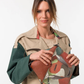 Esta carteira redefine o conceito de versatilidade com uma proposta única: duas carteiras numa só.

A bolsa principal impressiona pelo seu padrão artístico em tons de laranja, verde, bege e terracota, com uma textura trabalhada que evoca o espírito aventureiro e cosmopolita da coleção Odyssey. Os detalhes em metal gunmetal, a corrente com pendente em forma de nuvem e as alças em couro sintético castanho-escuro completam um visual rico e distinto.