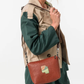 Esta carteira redefine o conceito de versatilidade com uma proposta única: duas carteiras numa só.

A bolsa principal impressiona pelo seu padrão artístico em tons de laranja, verde, bege e terracota, com uma textura trabalhada que evoca o espírito aventureiro e cosmopolita da coleção Odyssey. Os detalhes em metal gunmetal, a corrente com pendente em forma de nuvem e as alças em couro sintético castanho-escuro completam um visual rico e distinto.