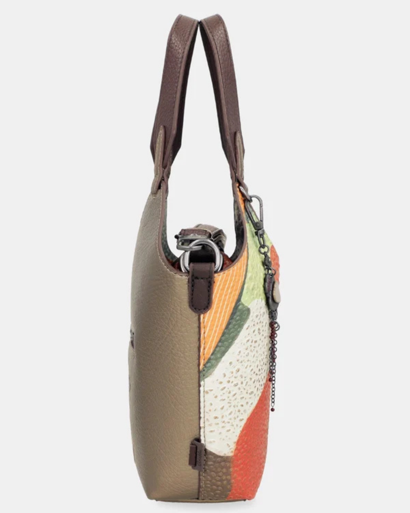 Esta carteira redefine o conceito de versatilidade com uma proposta única: duas carteiras numa só.

A bolsa principal impressiona pelo seu padrão artístico em tons de laranja, verde, bege e terracota, com uma textura trabalhada que evoca o espírito aventureiro e cosmopolita da coleção Odyssey. Os detalhes em metal gunmetal, a corrente com pendente em forma de nuvem e as alças em couro sintético castanho-escuro completam um visual rico e distinto.