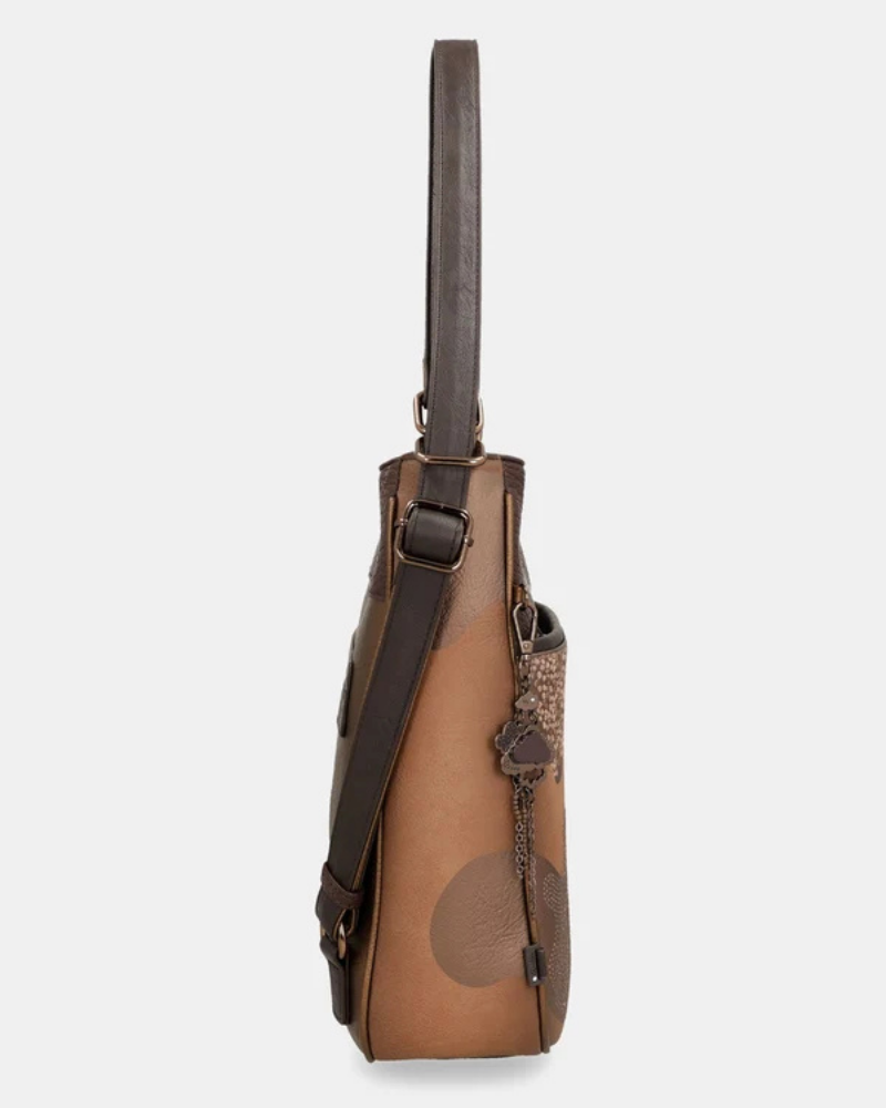 Esta é a peça perfeita para a mulher que valoriza versatilidade sem abrir mão do estilo.

Com um design bicolor que combina caramelo e castanho escuro, esta bolsa destaca-se pelos detalhes em relevo inspirados na coleção Voyage — motivos florais, silhuetas femininas e a inconfundível assinatura da marca gravada no material — conferindo-lhe uma personalidade única e intemporalmente sofisticada.