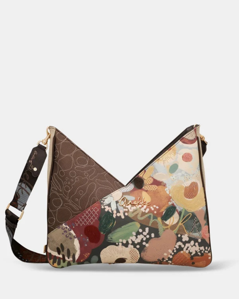 Uma carteira de ombro que celebra a cor, a arte e a liberdade numa peça de grande formato e impacto visual imediato.

O seu design em patchwork combina um painel em couro sintético castanho-escuro com bordado tonal em relevo — onde florescem motivos orgânicos e a silhueta inconfundível da personagem Anekke — com um segundo painel em impressão artística de inspiração botânica, com flores, frutos e manchas de cor em tons de laranja, verde, bege e bordô.