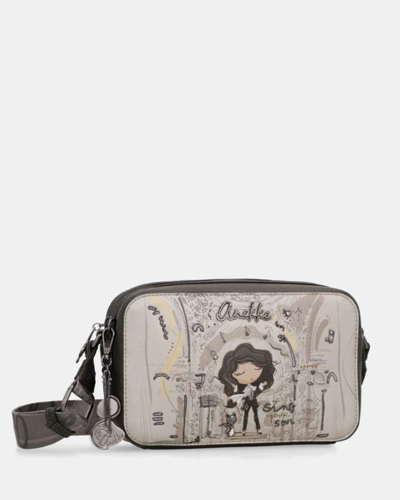 Esta carteira é a companheira perfeita para quem procura estilo e praticidade num formato compacto.

Com uma silhueta retangular e estrutura rígida, esta carteira destaca-se pelo seu acabamento metálico prateado com reflexos pérola, que lhe confere um aspeto sofisticado e contemporâneo. A parte frontal apresenta a ilustração exclusiva da personagem Anekke numa cenografia de inspiração clássica e musical, com detalhes arquitetónicos e elementos de cena que tornam cada peça verdadeiramente única.