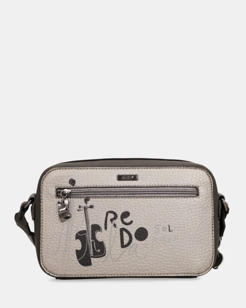 Esta carteira é a companheira perfeita para quem procura estilo e praticidade num formato compacto.

Com uma silhueta retangular e estrutura rígida, esta carteira destaca-se pelo seu acabamento metálico prateado com reflexos pérola, que lhe confere um aspeto sofisticado e contemporâneo. A parte frontal apresenta a ilustração exclusiva da personagem Anekke numa cenografia de inspiração clássica e musical, com detalhes arquitetónicos e elementos de cena que tornam cada peça verdadeiramente única.