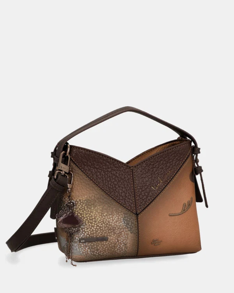 Uma carteira de carácter aventureiro e acabamento sofisticado.

Construída em patchwork de materiais sintéticos com diferentes texturas — grão fino, superfície metálica em cobre envelhecido e painel com estampado pontilhado iridescente —, esta mala de mão combina profundidade visual com uma silhueta estruturada e geométrica.