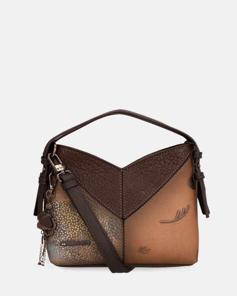 Uma carteira de carácter aventureiro e acabamento sofisticado.

Construída em patchwork de materiais sintéticos com diferentes texturas — grão fino, superfície metálica em cobre envelhecido e painel com estampado pontilhado iridescente —, esta mala de mão combina profundidade visual com uma silhueta estruturada e geométrica.
