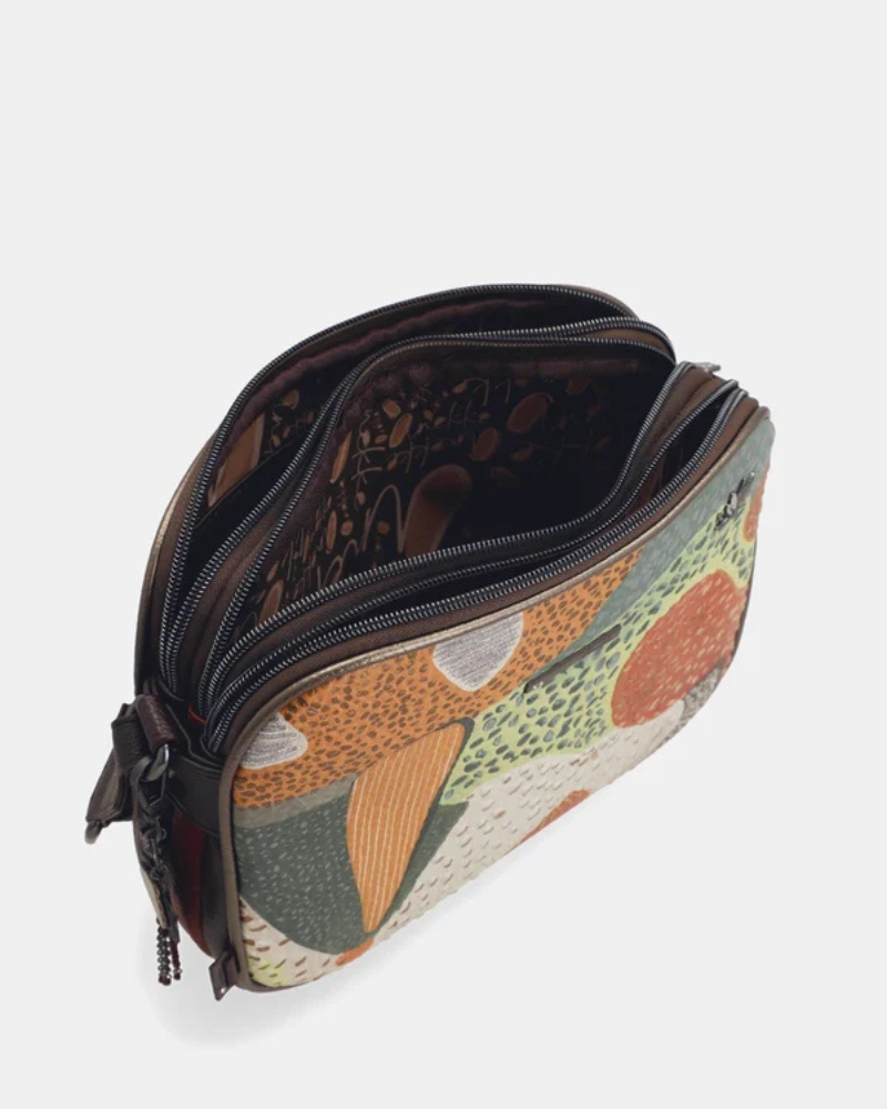 Esta carteira é uma declaração de estilo para quem não tem medo da cor.

Com um padrão artístico e vibrante que mistura formas geométricas, texturas e tons terrosos com toques de verde, vermelho e bege, esta carteira é uma peça que se destaca por si só — mesmo quando o resto do look é simples. Com dimensões generosas oferece espaço suficiente para o essencial do dia a dia, sem perder a leveza de uma carteira de tiracolo.