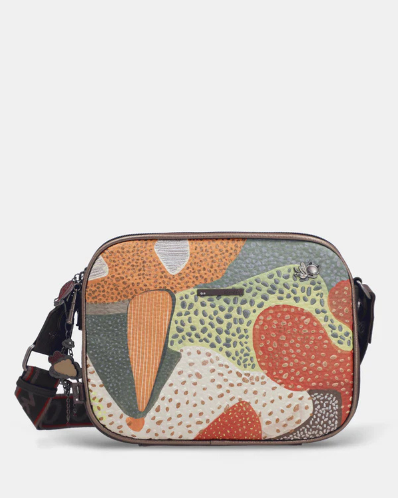 Esta carteira é uma declaração de estilo para quem não tem medo da cor.

Com um padrão artístico e vibrante que mistura formas geométricas, texturas e tons terrosos com toques de verde, vermelho e bege, esta carteira é uma peça que se destaca por si só — mesmo quando o resto do look é simples. Com dimensões generosas oferece espaço suficiente para o essencial do dia a dia, sem perder a leveza de uma carteira de tiracolo. 