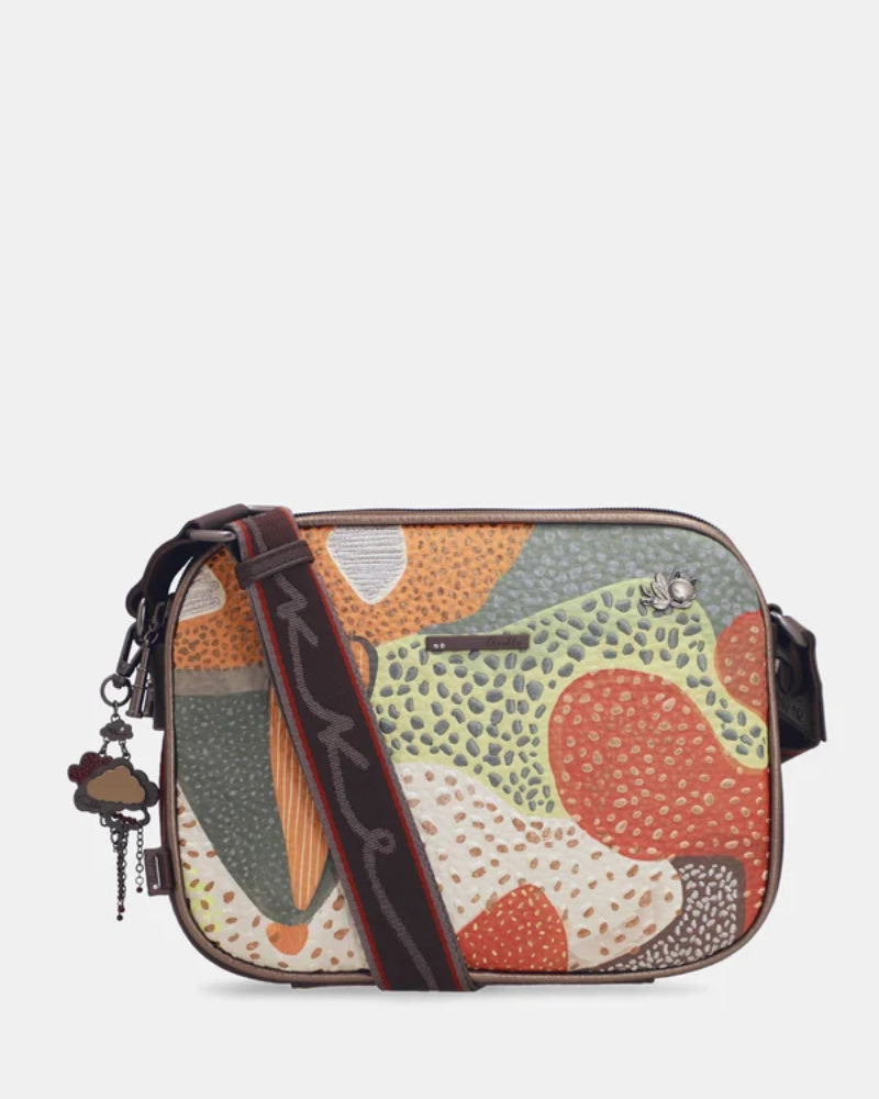 Esta carteira é uma declaração de estilo para quem não tem medo da cor.

Com um padrão artístico e vibrante que mistura formas geométricas, texturas e tons terrosos com toques de verde, vermelho e bege, esta carteira é uma peça que se destaca por si só — mesmo quando o resto do look é simples. Com dimensões generosas oferece espaço suficiente para o essencial do dia a dia, sem perder a leveza de uma carteira de tiracolo. 