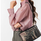 Uma peça que equilibra arte e funcionalidade.

Com um design gráfico exclusivo em tons de preto, bege e dourado envelhecido, esta carteira a tiracolo destaca-se pelo painel frontal com motivos caligráficos e detalhes em strass que captam a luz com subtileza.