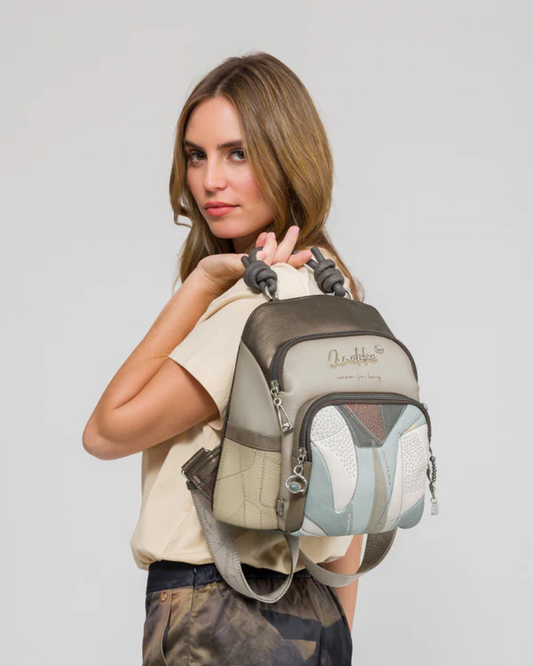 A mochila Auralis é a fusão perfeita entre funcionalidade urbana e design contemporâneo.

Com um padrão geométrico abstrato que combina tons de cinza, bege, azul suave e castanho, esta peça destaca-se pela sua estética arrojada e sofisticada. A estrutura compacta mas espaçosa foi pensada para o dia a dia da mulher moderna, oferecendo múltiplos compartimentos com fechos de correr que garantem organização e acesso fácil aos seus essenciais.