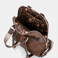 Uma mochila que eleva o conceito de acessório funcional a verdadeira peça de autor.

O seu exterior apresenta um padrão em patchwork com texturas e motivos em tons de verde-musgo, castanho, terracota e dourado, com apontamentos florais e geométricos que evocam a riqueza dos tecidos artesanais. A assinatura Anekke em lettering dourado, os detalhes em metal dourado e o pendente com logótipo completam um design sofisticado e inconfundível.