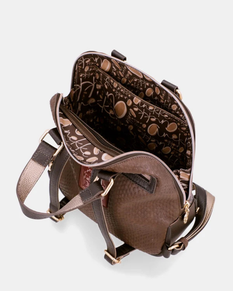 Uma mochila que eleva o conceito de acessório funcional a verdadeira peça de autor.

O seu exterior apresenta um padrão em patchwork com texturas e motivos em tons de verde-musgo, castanho, terracota e dourado, com apontamentos florais e geométricos que evocam a riqueza dos tecidos artesanais. A assinatura Anekke em lettering dourado, os detalhes em metal dourado e o pendente com logótipo completam um design sofisticado e inconfundível.