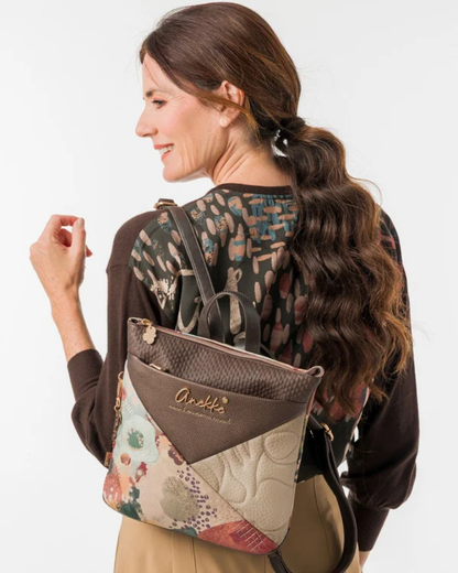 Uma mochila que reinventa a versatilidade com um design em patchwork sofisticado e cheio de personalidade.

O seu exterior combina painéis em couro sintético castanho com textura em relevo, patchwork floral em tons de creme, rosa e verde, e aplicações acolchoadas com motivos orgânicos — uma composição que celebra a feminilidade e o detalhe artesanal. A assinatura Anekke em lettering dourado e os detalhes em metal dourado completam uma estética refinada e distinta.