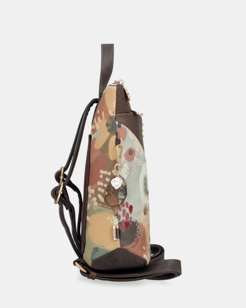 Uma mochila que reinventa a versatilidade com um design em patchwork sofisticado e cheio de personalidade.

O seu exterior combina painéis em couro sintético castanho com textura em relevo, patchwork floral em tons de creme, rosa e verde, e aplicações acolchoadas com motivos orgânicos — uma composição que celebra a feminilidade e o detalhe artesanal. A assinatura Anekke em lettering dourado e os detalhes em metal dourado completam uma estética refinada e distinta.