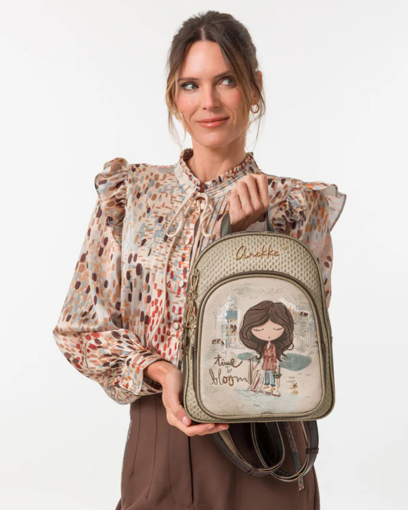 Esta mochila é uma peça que encanta à primeira vista.

O seu painel frontal apresenta a icónica personagem Anekke numa cena urbana e poética, acompanhada pela frase "time to bloom" — uma mensagem de renovação e leveza que define toda a coleção. O corpo em material trançado texturado em tom caqui-dourado, os detalhes em metal dourado e a assinatura Anekke bordada conferem-lhe uma elegância artesanal e uma personalidade distinta.
