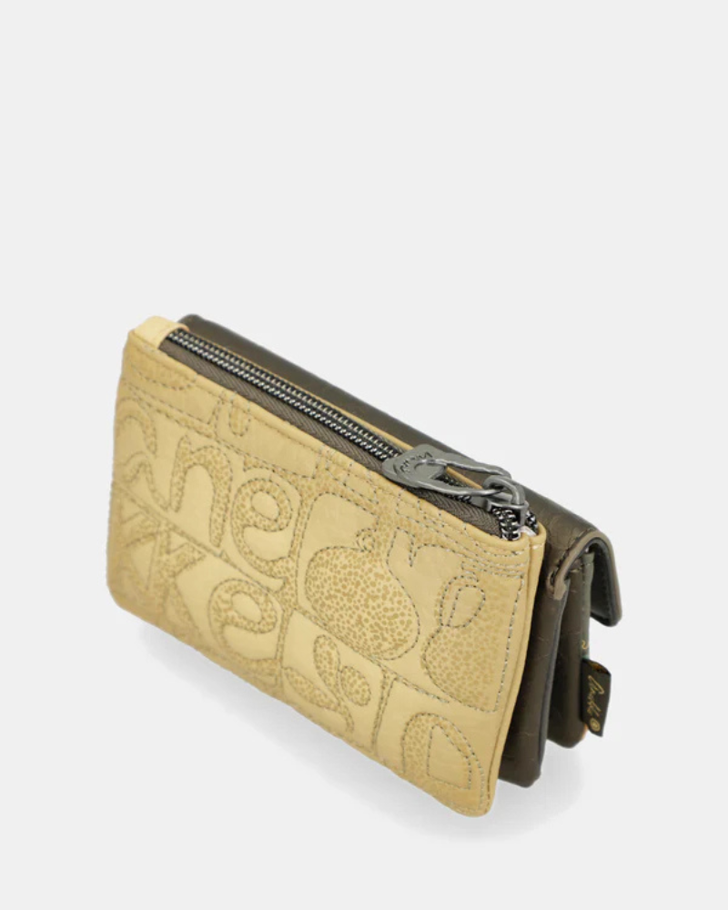 Este moedeiro alia praticidade e charme num design delicado e funcional.

Confeccionado em material de alta qualidade, apresenta uma elegante combinação de texturas e padrões inspirados na identidade única da marca, com detalhe do logótipo metálico na lapela que acrescenta um toque sofisticado. Este modelo tem um compartimento principal com fecho de zíper, ideal para guardar moedas e pequenos objetos de forma segura, além de um bolso frontal com lapela que facilita a organização.