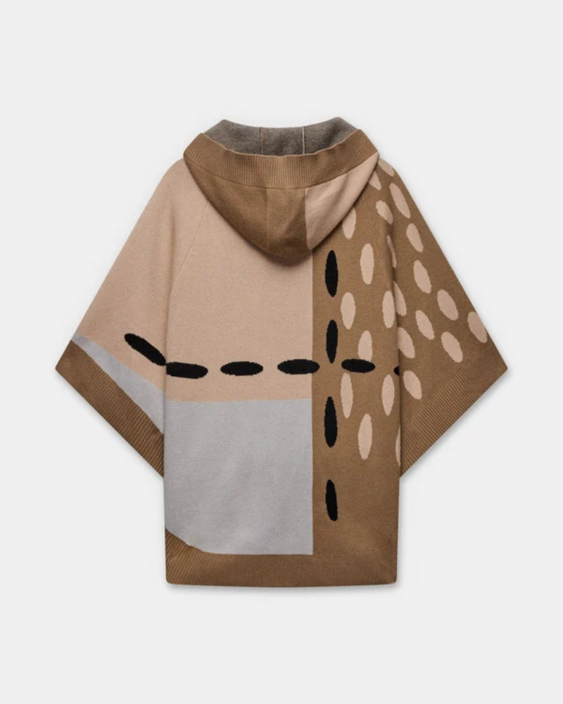 Este poncho é uma peça versátil que combina conforto e sofisticação numa silhueta única.

Confeccionado em malha de qualidade premium, apresenta um padrão exclusivo inspirado na girafa, com manchas em tons de bege, creme e preto que lhe conferem um carácter editorial e atemporal. O capuz estruturado com acabamento em canelado, as mangas curtas amplas e os bolsos frontais tornam-no tão funcional quanto elegante. 