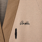 Este poncho é uma peça versátil que combina conforto e sofisticação numa silhueta única.

Confeccionado em malha de qualidade premium, apresenta um padrão exclusivo inspirado na girafa, com manchas em tons de bege, creme e preto que lhe conferem um carácter editorial e atemporal. O capuz estruturado com acabamento em canelado, as mangas curtas amplas e os bolsos frontais tornam-no tão funcional quanto elegante. 