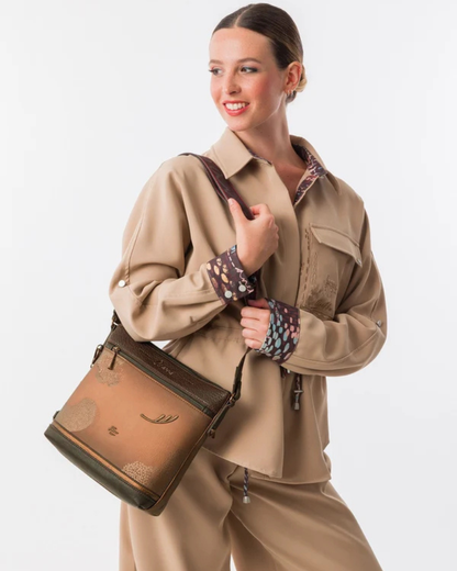 Esta carteira combina elegância discreta com um espírito de aventura.

Em tons camel e bege com base em verde escuro e detalhes em textura croc, esta carteira tem uma sofisticação natural que se adapta tanto a um look casual como a uma ocasião mais cuidada. A silhueta quadrada e estruturada, com bolso frontal com fecho de correr, organiza o essencial com estilo, enquanto a alça de tiracolo com padrão estampado — um toque de personalidade Anekke — permite usá-la ao ombro ou a tiracolo.