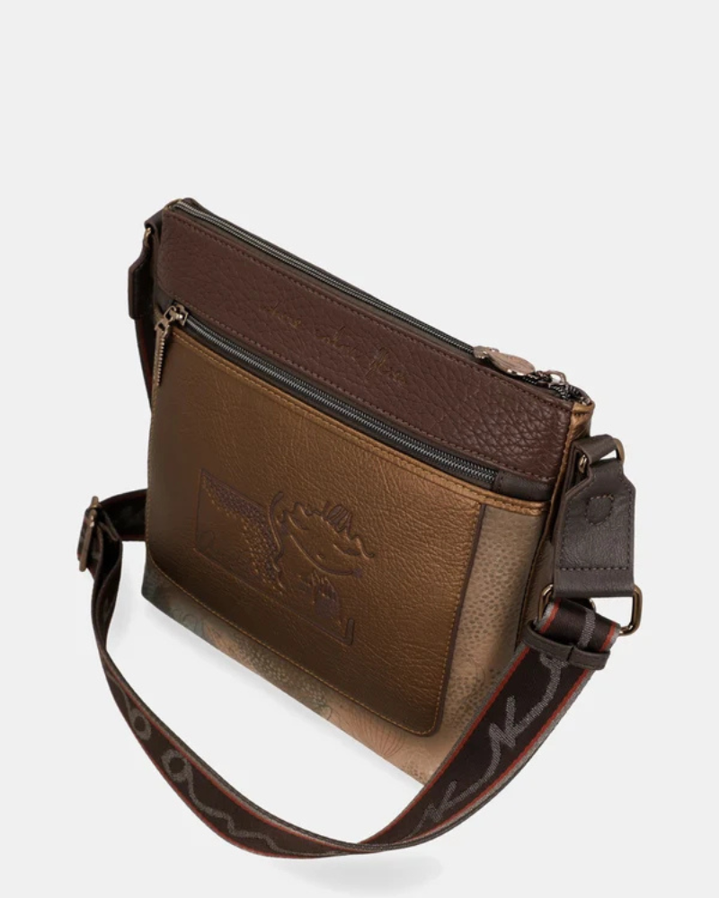 Esta carteira combina elegância discreta com um espírito de aventura.

Em tons camel e bege com base em verde escuro e detalhes em textura croc, esta carteira tem uma sofisticação natural que se adapta tanto a um look casual como a uma ocasião mais cuidada. A silhueta quadrada e estruturada, com bolso frontal com fecho de correr, organiza o essencial com estilo, enquanto a alça de tiracolo com padrão estampado — um toque de personalidade Anekke — permite usá-la ao ombro ou a tiracolo.
