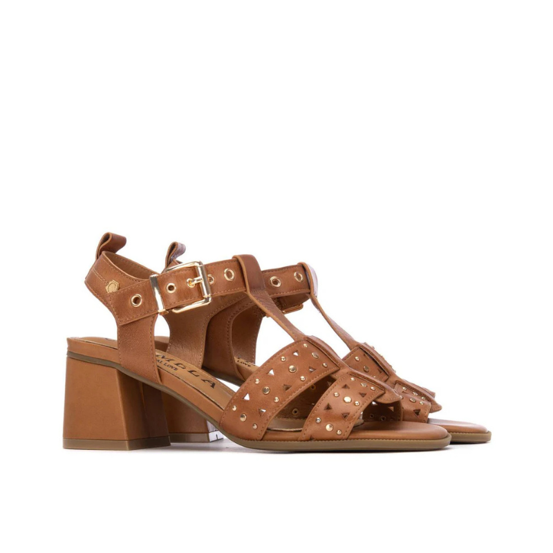 Esta sandália camel combina feminilidade e atitude numa silhueta de salto bloco médio.

As tiras em T com recortes geométricos e aplicações de tachas douradas conferem personalidade e detalhe ao design, enquanto a fivela dourada no tornozelo garante um ajuste seguro e elegante. O salto bloco de altura média oferece conforto e estabilidade ao longo do dia, tornando-a uma escolha versátil para ocasiões que pedem um toque mais sofisticado.